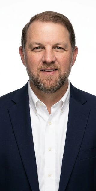Professional headshot of Jason Kokenzie wearing a dark navy blazer and white button-up shirt
